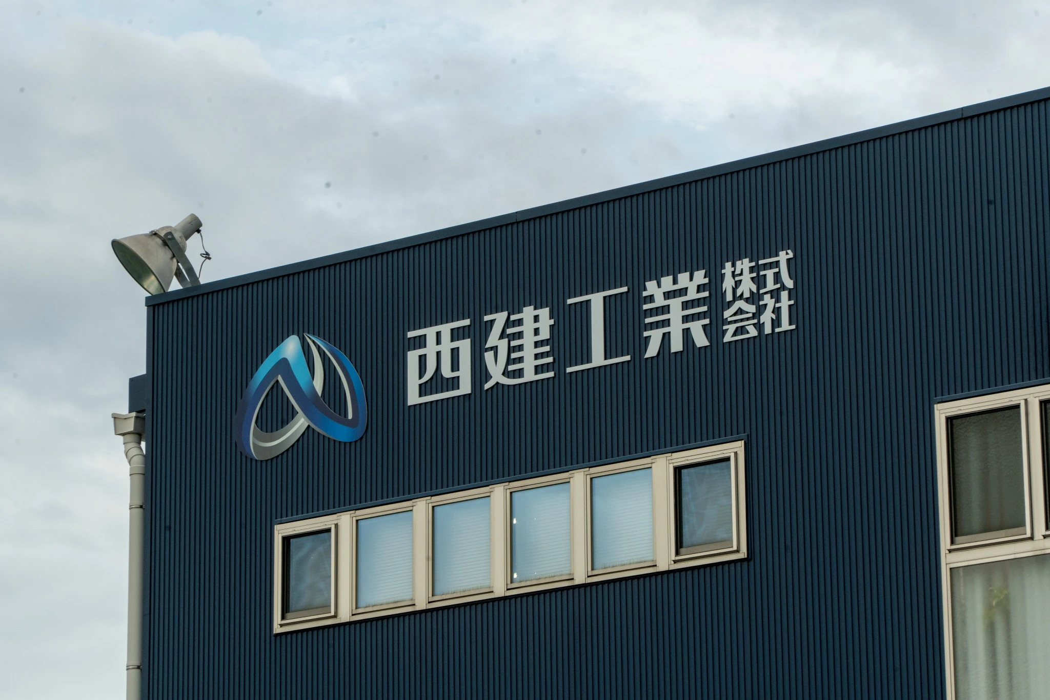 西建工業株式会社の社名が掲げられた社屋